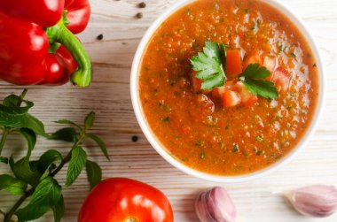 Soğuk yaz çorbası Gazpacho beyaz kâse içinde malzemeler masada. Geleneksel İspanyol mutfağı. Vejetaryen ya da vejetaryen. Seçici odaklanma. Yatay oryantasyon. Üst görünüm.