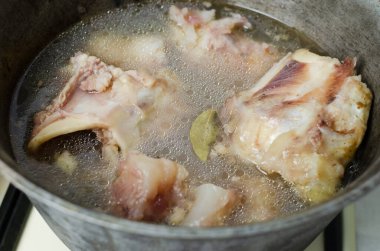 Çiğ dana kemiklerinden elde edilen et suyu bir kazanda 12 saat pişirildi. Kolajen konsepti. Seçici odaklanma. Yatay yönelim.