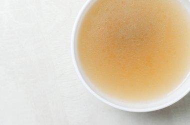 Beyaz bir masada beyaz bir kasede dana kemiği çorbası. Kolajen konsepti. Seçici odaklanma. Yatay oryantasyon. Uzayı kopyala Üst görünüm