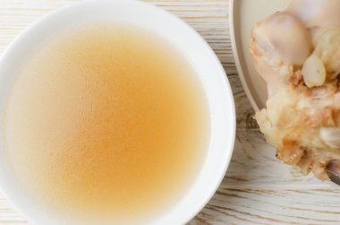 Beyaz bir masada beyaz bir kasede dana kemiği çorbası. Kolajen konsepti. Seçici odaklanma. Yatay oryantasyon. Üst görünüm