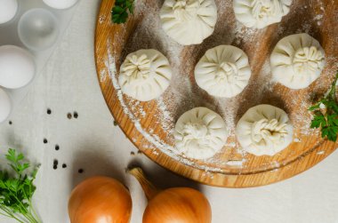 Maydanozlu, yumurtalı ve soğanlı, un kaplı çiğ khinkali. Geleneksel Gürcü mutfağı kavramı. Yatay oryantasyon. Seçici odaklanma. en üstteki görünüm