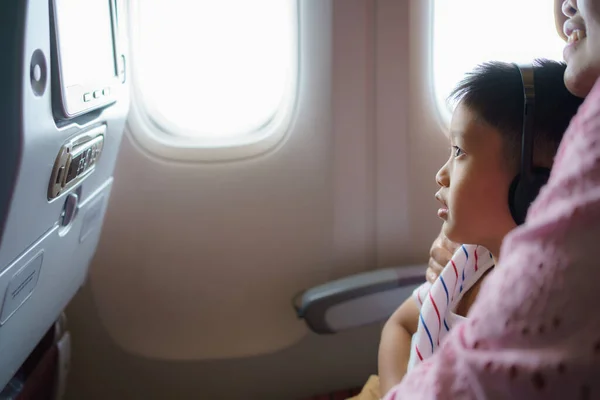 아시아 아이가 비행기 여행을 어머니와 만화를 즐기고 있습니다 아이들의 — 스톡 사진