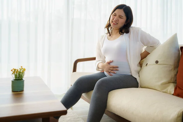 Asiatisk Gravid Kvinna Som Lider Ryggvärk Sitter Soffan Håller Magen — Stockfoto