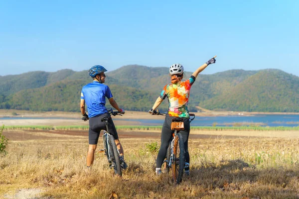 Asiatisches Radlerpaar Blickt Auf See Und Berge Und Plaudert Während — Stockfoto