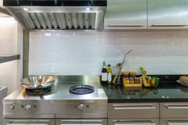 Modern bir mutfağın iç çekimleri. Parlak bir soba, şık bir lavabo ve sofistike bir egzoz kapağı olan bu alan, fonksiyonel tasarımın ve çağdaş zarafetin mükemmel bir birleşimini temsil ediyor.