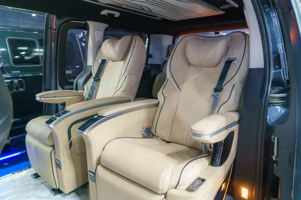 Interior of a luxury minivan, adorned with plush leather seats. Each seat exudes comfort and sophistication, creating an ambiance of indulgence for discerning travelers