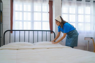 Hizmetçi, yatak odasının profesyonelliğini ve temizlik ekibinin kendini işine adamasını ustalıkla ayarlar ve yumuşatır.