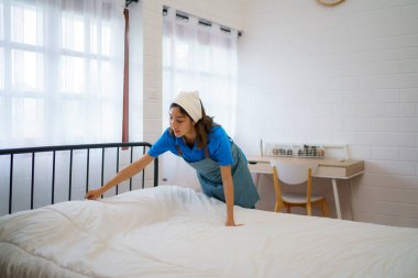 Hizmetçi, yatak odasının profesyonelliğini ve temizlik ekibinin kendini işine adamasını ustalıkla ayarlar ve yumuşatır.