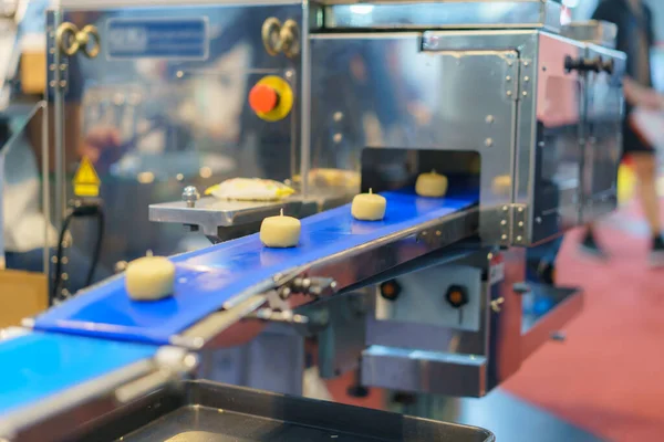 青いコンベヤベルトの生地部分を示す自動化された産業食品加工システムのクローズアップ画像 バックグラウンドの機械要素 — ストック写真