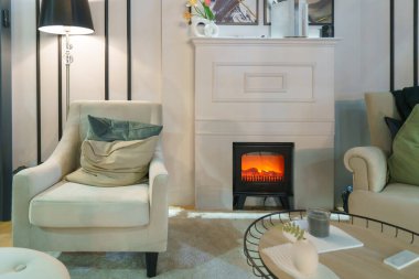 Sıcak ve davetkar bir oturma odası, rahat bir kanepe ve büyüleyici bir şömine.