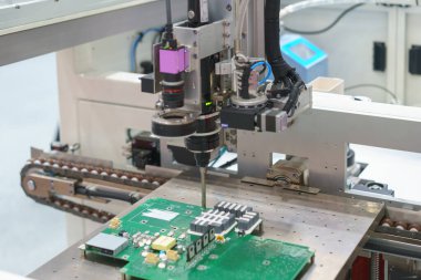 Otomatik makine, modern üretim teknolojisinin hassasiyetini ve verimliliğini yansıtan bir devre kartı monte ediyor..