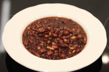 Beyaz tabakta pişmiş kırmızı fasulye.