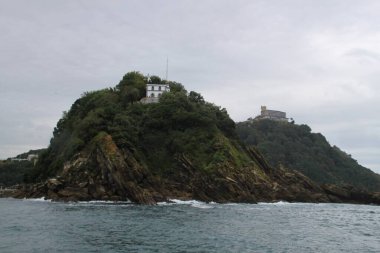 Donostia San Sebastian 'daki La Concha körfezindeki deniz feneri ve Santa Clara adası manzarası