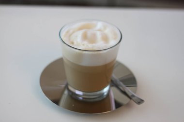 Latte coffee with white foam in a glass cup