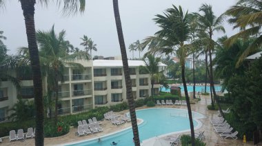 Punta Cana, Dominik Cumhuriyeti, 22 Ağustos 2023: Turistler havuzda banyo yapmaya devam ederken, Punta Cana 'daki bir tatil köyünde şiddetli yağmur yağdı