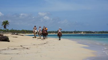 Uvero Alto, Punta Cana, Dominik Cumhuriyeti, 29 Ağustos 2023: Uvero Alto, Punta Cana, Dominik Cumhuriyeti 'nde güzel bir plaj boyunca at sırtında turist gezisi