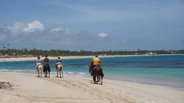 Uvero Alto, Punta Cana, Dominik Cumhuriyeti, 29 Ağustos 2023: Uvero Alto, Punta Cana, Dominik Cumhuriyeti 'nde güzel bir plaj boyunca at sırtında turist gezisi