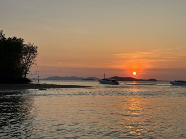 Phuket 'ten gün doğumunda Tayland, Asya' daki Phi Phi Adaları 'na giden bir tekne.