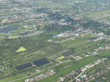 Bangkok havaalanı, Tayland, Hindiçin, Asya 'ya yaklaşırken uçaklardan görülen bol miktarda yağmurdan kaynaklanan tarım arazileri ve binalar.