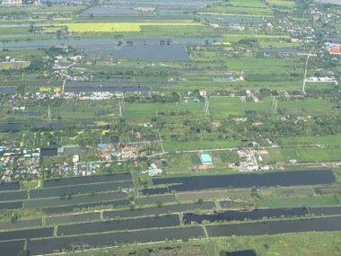 Bangkok havaalanı, Tayland, Hindiçin, Asya 'ya yaklaşırken uçaklardan görülen bol miktarda yağmurdan kaynaklanan tarım arazileri ve binalar.