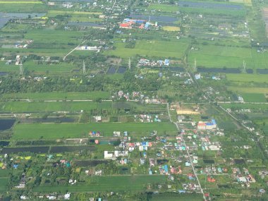 Bangkok havaalanı, Tayland, Hindiçin, Asya 'ya yaklaşırken uçaklardan görülen bol miktarda yağmurdan kaynaklanan tarım arazileri ve binalar.