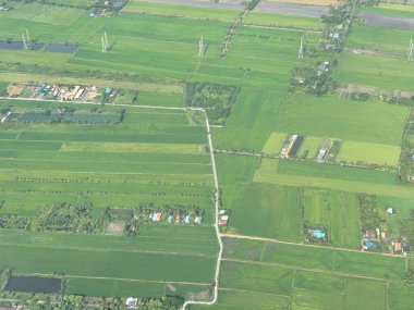 Bangkok havaalanı, Tayland, Hindiçin, Asya 'ya yaklaşırken uçaklardan görülen bol miktarda yağmurdan kaynaklanan tarım arazileri ve binalar.