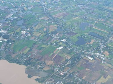 Bangkok havaalanı, Tayland, Hindiçin, Asya 'ya yaklaşırken uçaklardan görülen bol miktarda yağmurdan kaynaklanan tarım arazileri ve binalar.