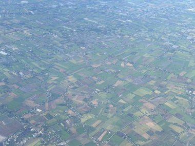 Bangkok havaalanı, Tayland, Hindiçin, Asya 'ya yaklaşırken uçaklardan görülen bol miktarda yağmurdan kaynaklanan tarım arazileri ve binalar.