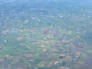 Bangkok havaalanı, Tayland, Hindiçin, Asya 'ya yaklaşırken uçaklardan görülen bol miktarda yağmurdan kaynaklanan tarım arazileri ve binalar.