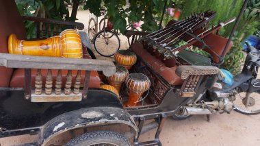 Eski bir arabanın dikey görüntüsü ve caddede tahta bir tekerlek.