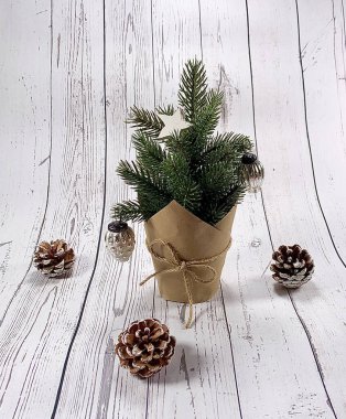 Yılbaşı ağacı süslemeleriyle yatıyordu. Noel arkaplanı ahşap masada. Duvar kağıdında ışık ve koni olan Noel aksesuarları. Kısa mesaj için yeri olan bayram arkaplanı.