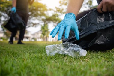 Volunteer man collecting trash and reusing plastic cleanup to recycle