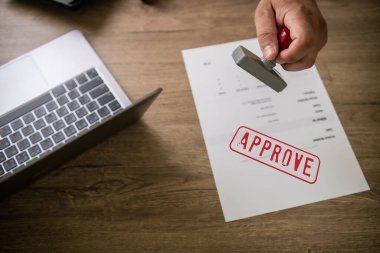 man stamping approval Text is approved by stamping the document on paper.