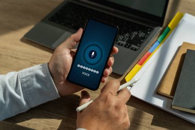 Akıllı telefon ekranını tutan ses kaydeden bir adam mobil bir uygulamada dil ve iletişim için yapay zeka teknolojisi üretir. Kayıt sesi