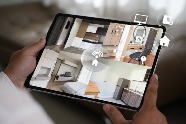 Kapalı devre güvenlik sistemi çalışanı akıllı telefondan ekrandaki kamera görüntülerini izliyor.