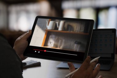Tablet Film 'in evde yayınlanan uygulamasından online video izleyen adam