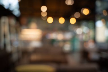 Bokeh arkaplanlı bulanık kahve ahşap masaları, parlak ışıkları ve klasik bir tasarımı olan güzel, modern bir kafe rahat, rahatlatıcı bir yaşam tarzı yaratıyor..