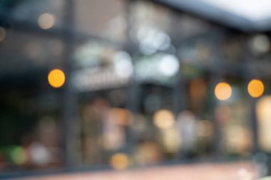 Bokeh arkaplanlı bulanık kahve ahşap masaları, parlak ışıkları ve klasik bir tasarımı olan güzel, modern bir kafe rahat, rahatlatıcı bir yaşam tarzı yaratıyor..