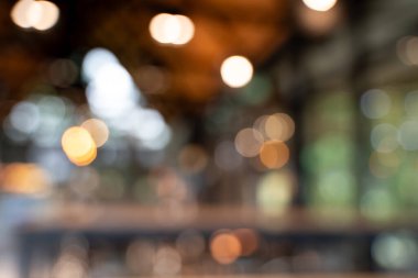 Bokeh arkaplanlı bulanık kahve ahşap masaları, parlak ışıkları ve klasik bir tasarımı olan güzel, modern bir kafe rahat, rahatlatıcı bir yaşam tarzı yaratıyor..