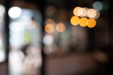 Bokeh arkaplanlı bulanık kahve ahşap masaları, parlak ışıkları ve klasik bir tasarımı olan güzel, modern bir kafe rahat, rahatlatıcı bir yaşam tarzı yaratıyor..