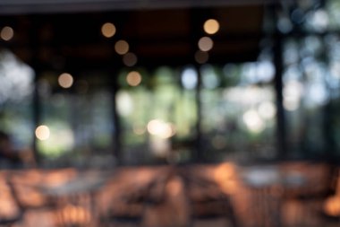 Bokeh arkaplanlı bulanık kahve ahşap masaları, parlak ışıkları ve klasik bir tasarımı olan güzel, modern bir kafe rahat, rahatlatıcı bir yaşam tarzı yaratıyor..