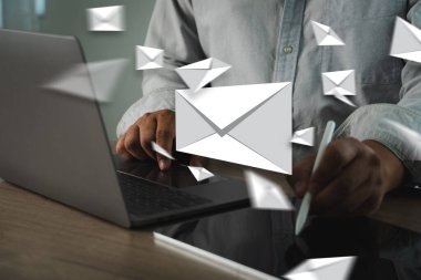 Yüzen e- posta simgeleri ve zarfları, e-posta iletişimini veya dijital mesajlaşmayı sembolize eden, dizüstü bilgisayarda çalışan bir e-posta kutusu ve e-posta göndericisi