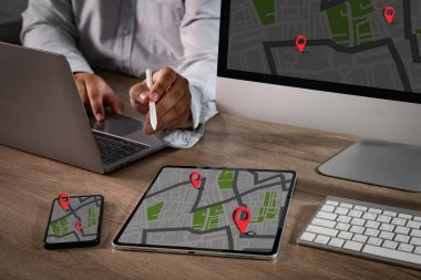 Çoklu akıllı aygıtlarda gösterilen kırmızı konum pimleri ile dijital GPS haritası, çapraz platform sistemlerinde modern navigasyon, konum izleme, rota planlaması ve GPS teknolojisini temsil eder..