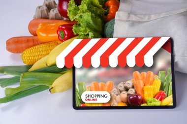 Taze sebze, meyve, ekmek ve yumurtaları tablet ekranda gösteren çevrimiçi market alışverişi kavramı, tüketicilerin e-ticaret ve hızlı dağıtım hizmetleri yoluyla sağlıklı gıdaları nasıl satın aldıklarını gösteriyor..