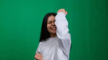 Coşkulu bir zafer. Stüdyo portresindeki neşeli kadın mutluluk ve başarı saçıyor, zafer anını ışıl ışıl bir gülümseme ve pozitif enerjiyle kutluyor. Yüksek kalite 4k görüntü