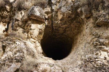 Mağara. Tepenin kenarındaki kayada bir delik.