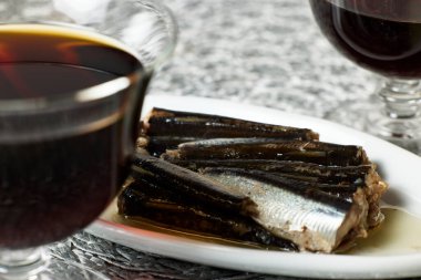 Atıştırmalıklı bir masa. Yağ içinde bir tabak sardalya. 