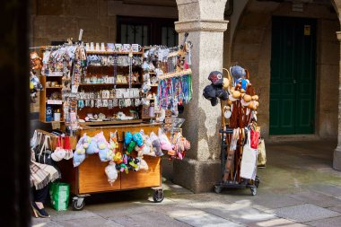 Santiago de Compostela (İspanya), 17 Temmuz 2023. Toplu turizm. Caddedeki hediyelik eşya tezgahı. Turizm düzenlemesi birçok şehirde gereklidir..