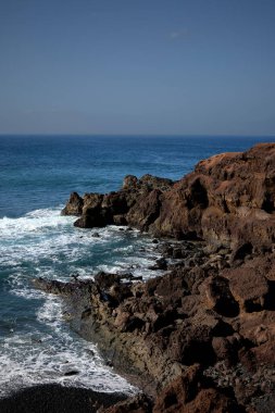 Sea and rocks. Cliffs in El Golfo, a coastal village on the island of Lanzarote (Spain). clipart