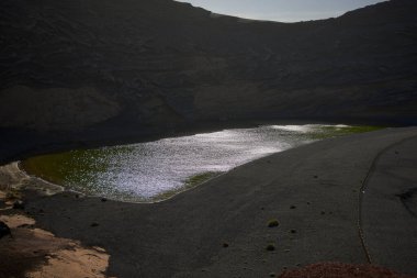Lago Verde, El Golfo (İspanya). Charco de los Clicos olarak da bilinir. Suyun yeşil rengi Ruppia maritima alglerinin birleşiminden ve volkanik aktiviteden kaynaklanan çözünmüş sülfür miktarından kaynaklanıyor..